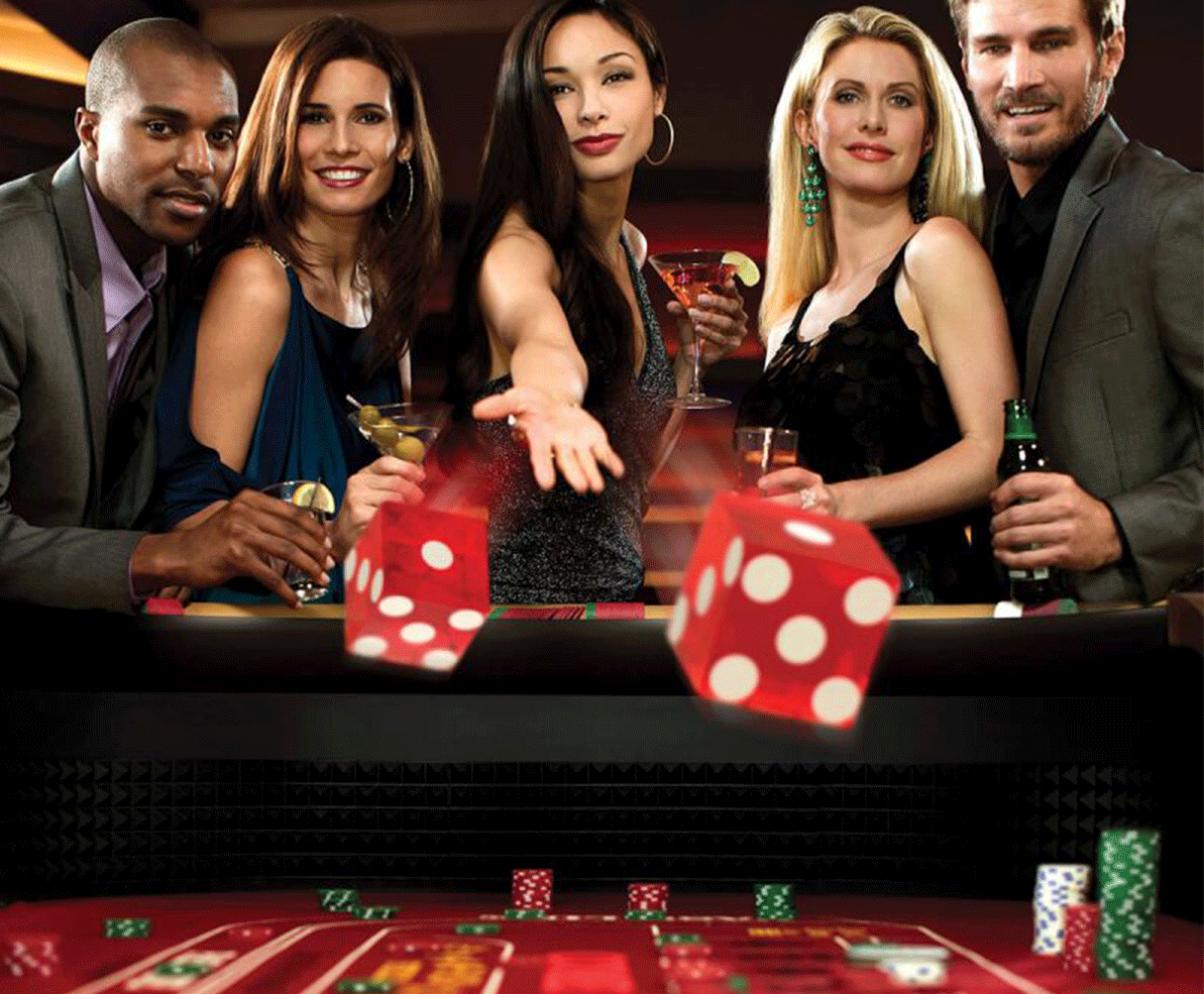 Привлекательные девушки в вечерних платьях отдыхают в казино за игрой в крэпс в компании своих парней