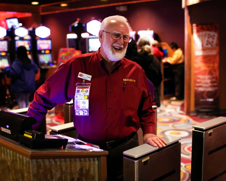 Cотрудник безопасности казино у игровых автоматов