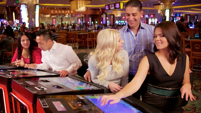 Блондинка и брюнетка раскручивают мужчину на игру в автоматы в казино