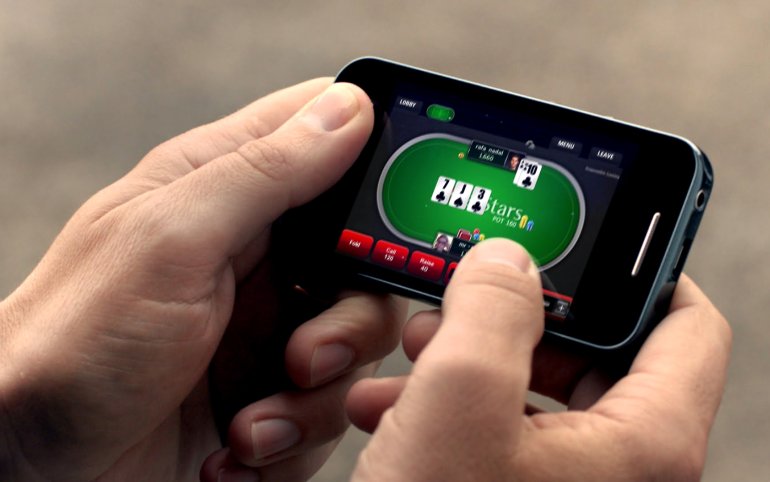 Человек играет в покер на мобильном телефоне