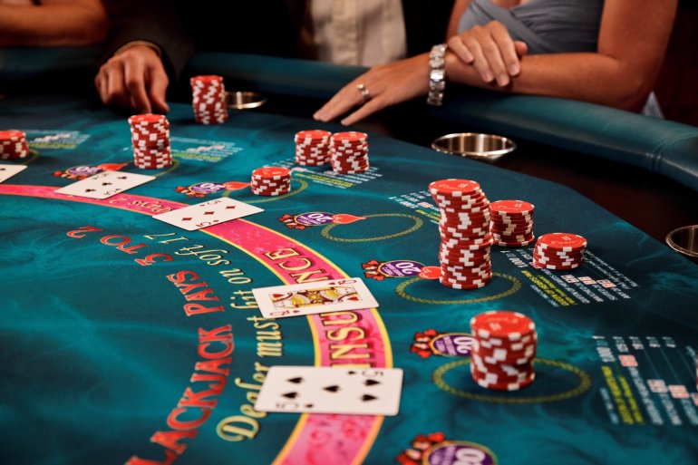 Стол для игры в блэкджек, окруженный азартными игроками