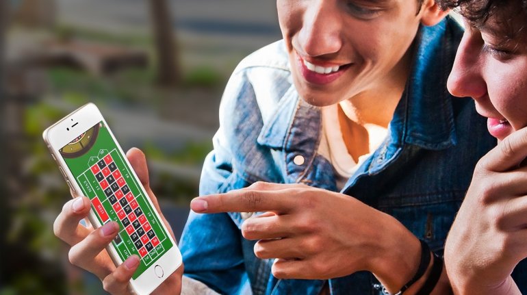 Двое парней играют в онлайн рулетку на айфоне